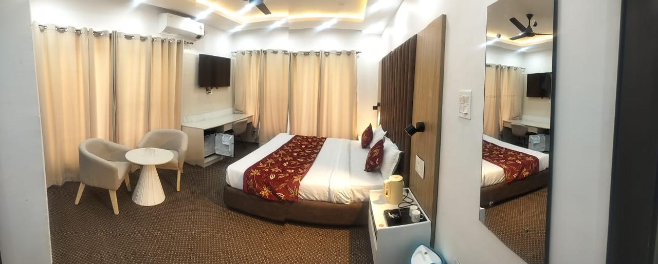 Guest bedroom with warm ceiling lighting and armchairs